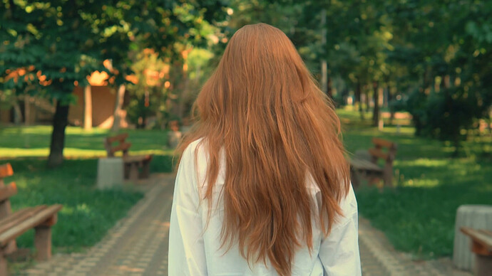 videoblocks-back-view-woman-with-red-long-hair-walking-on-the-street-summer-season-female-turn-to-the-camera-happy-smiling-nature-background-with-green-trees_hvuqh0nub_thumbnail-1080_01