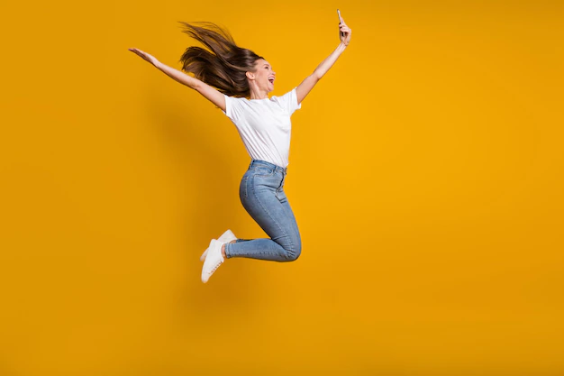 full-length-body-size-photo-woman-taking-selfie-throwing-hair-jumping-laughing-isolated-vivid-yellow-color-background_274222-39310